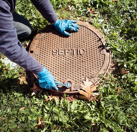 Septic tank lid being closed. Harts repairs the sewer line leading up to this point, not the tank itself.