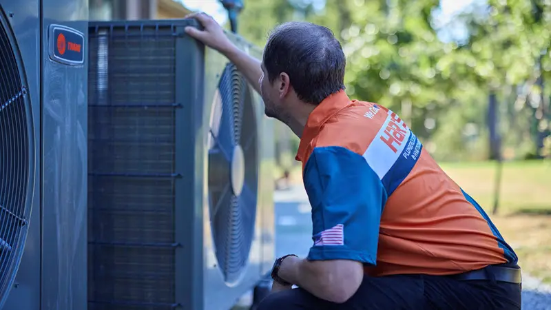 Harts HVAC technician inspecting and servicing a Trane heat pump system in Silverdale.