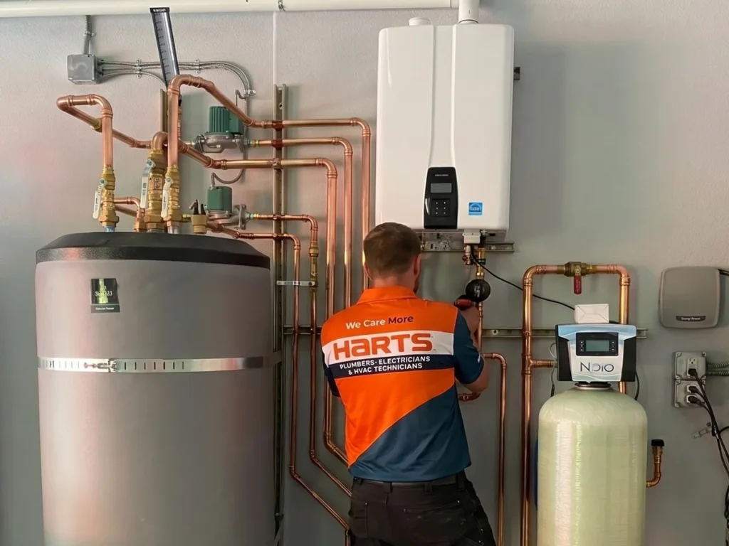 Harts technician evaluating tank and tankless water heater equipment