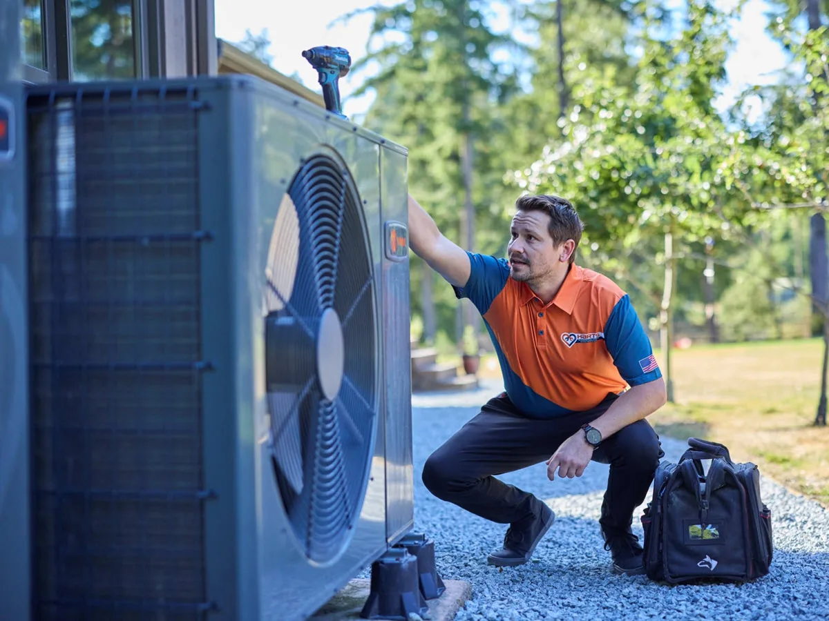 Harts HVAC technician inspecting an outdoor cooling system