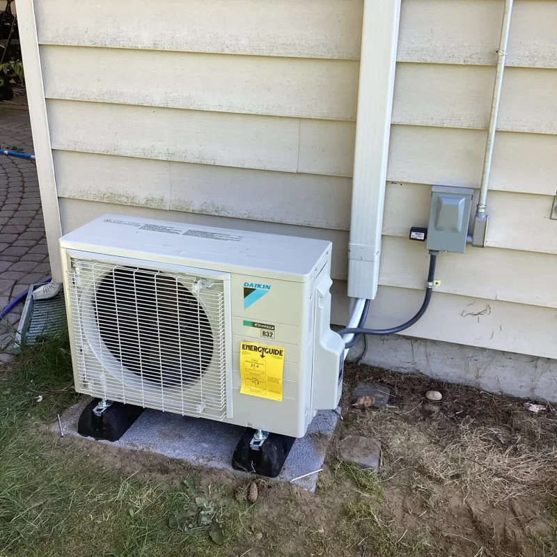 Daikin mini split outdoor unit installed next to home exterior wall