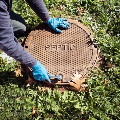 septic-sewer-plumber Septic tank lid being closed. Harts repairs the sewer line leading up to this point, not the tank itself.